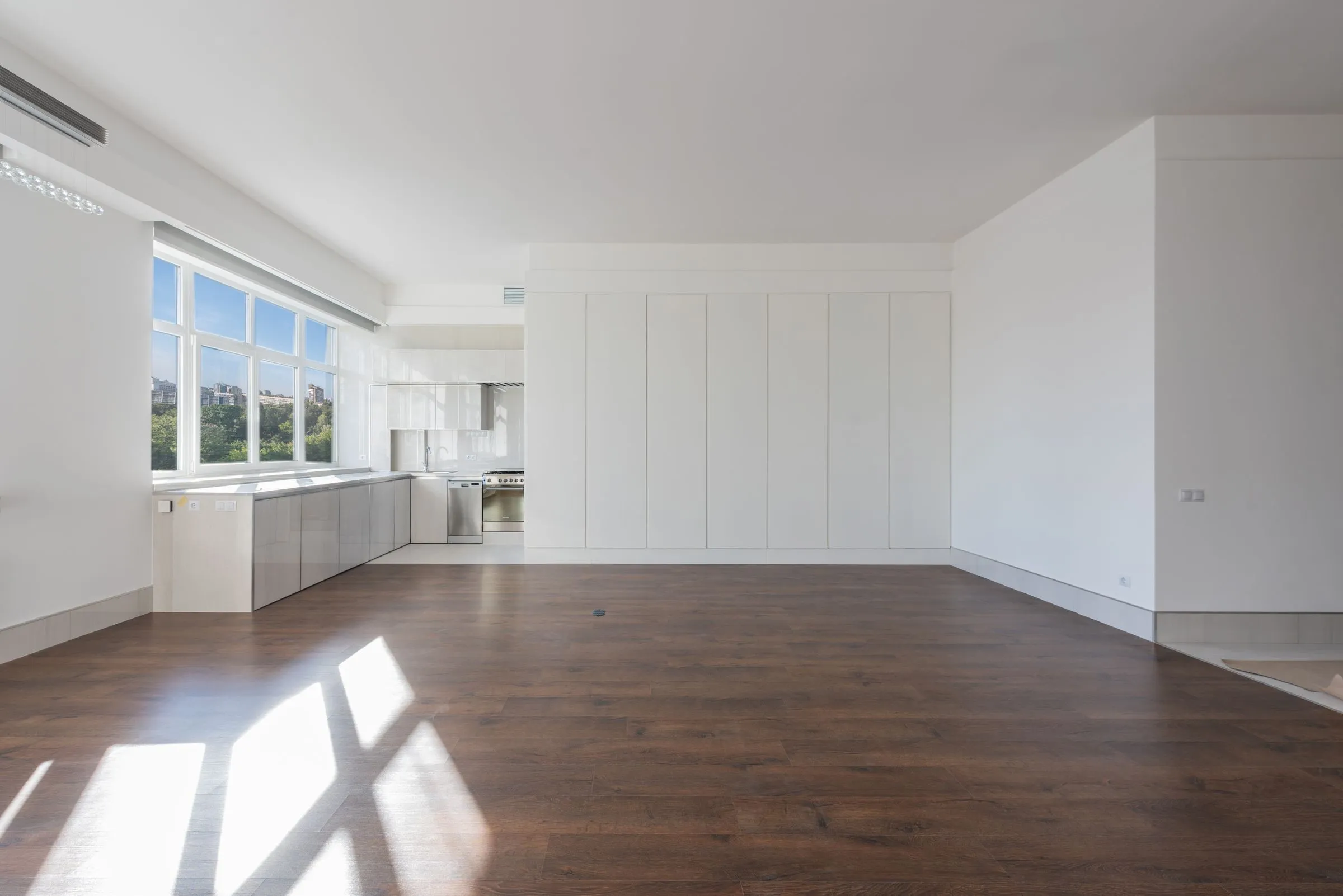 Helle, leere Wohnung mit Einbauküche und Parkett